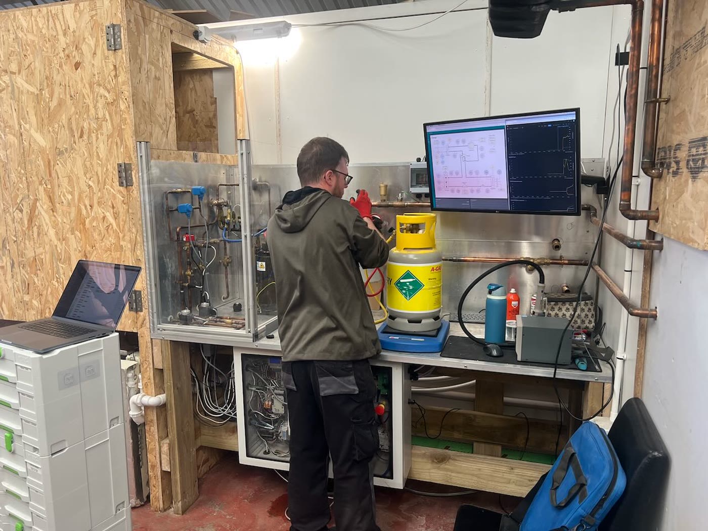 Workshop commissioning setup with test equipment and dashboard screens